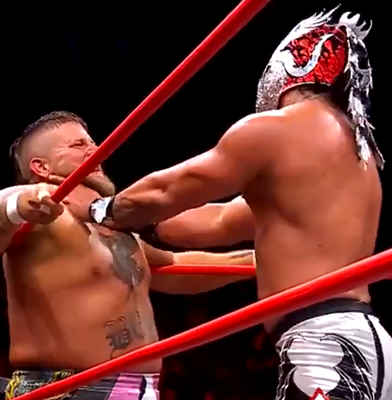 A screenshot of Dralistico,w ith his hands at BEEF's throat and pressing him into the corner of the ring.